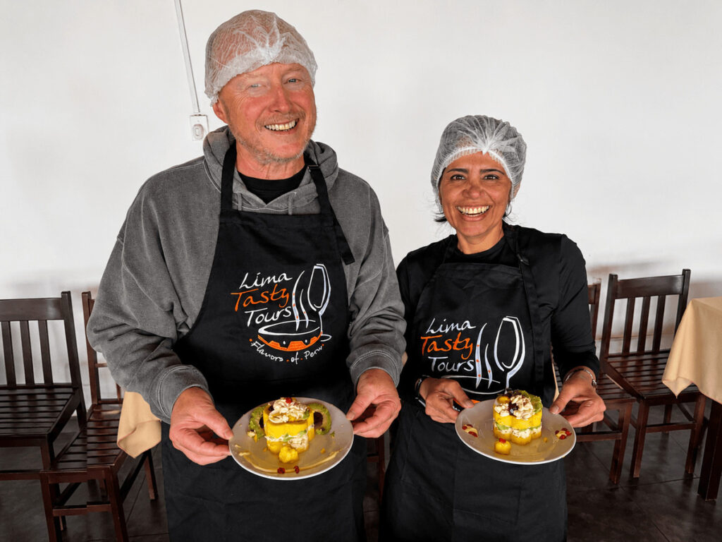 Smiling tourists wearing hygienic hairnets showing their perfectly prepared and customizable traditional Causa Limeña dishes.⁠